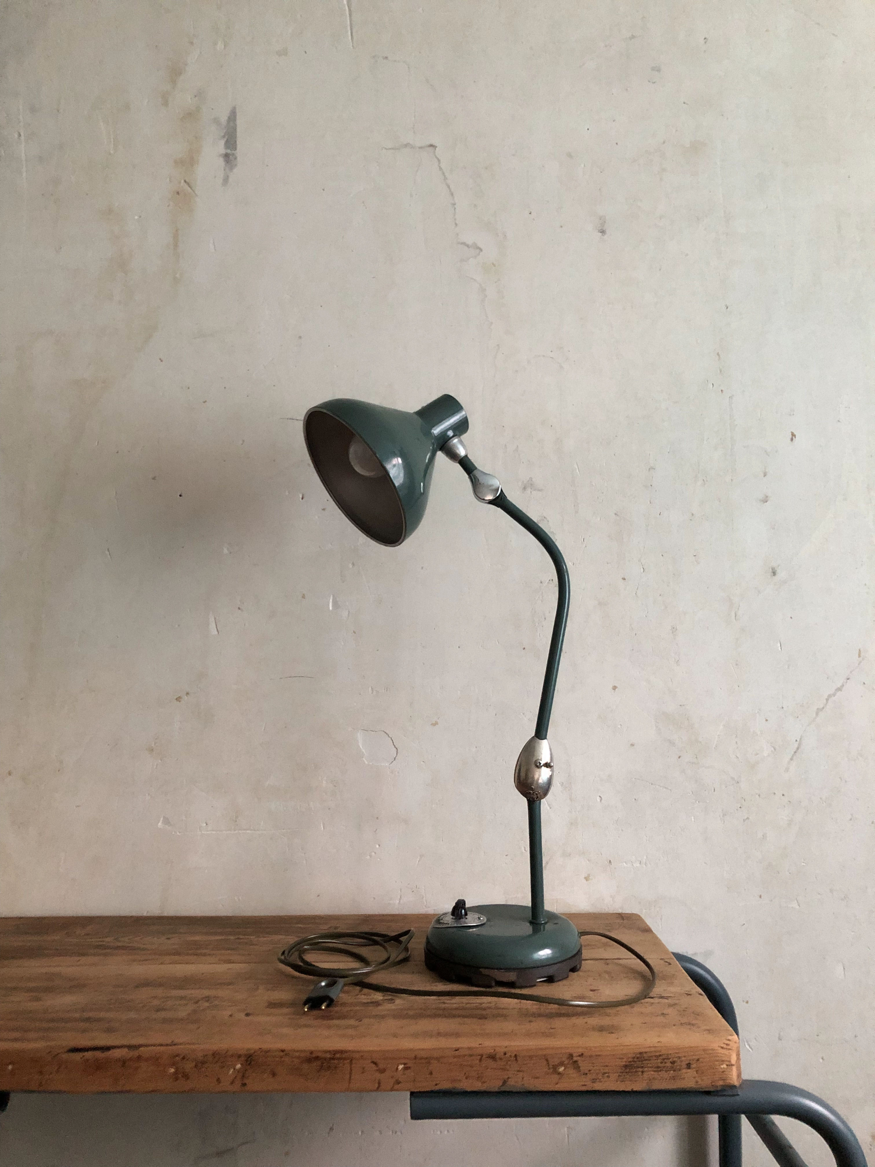 La lampe Claria éteinte, légèrement tournée et posée sur un bureau