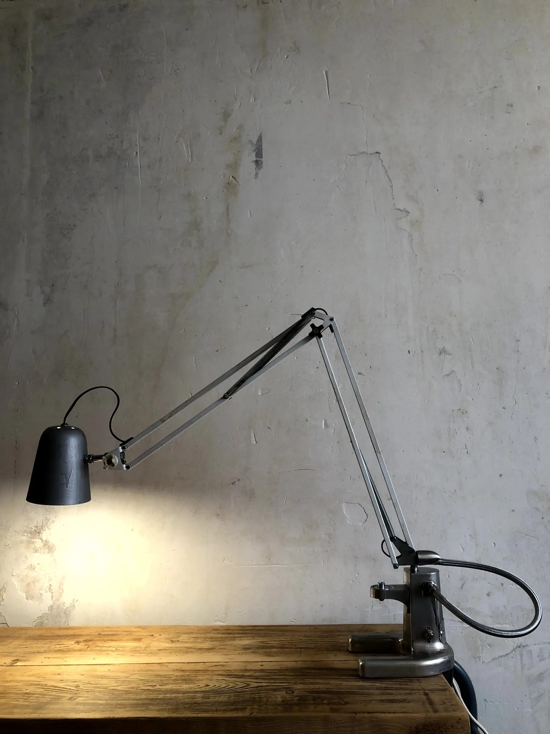 La lampe Luxo allumée et fixée sur un bureau