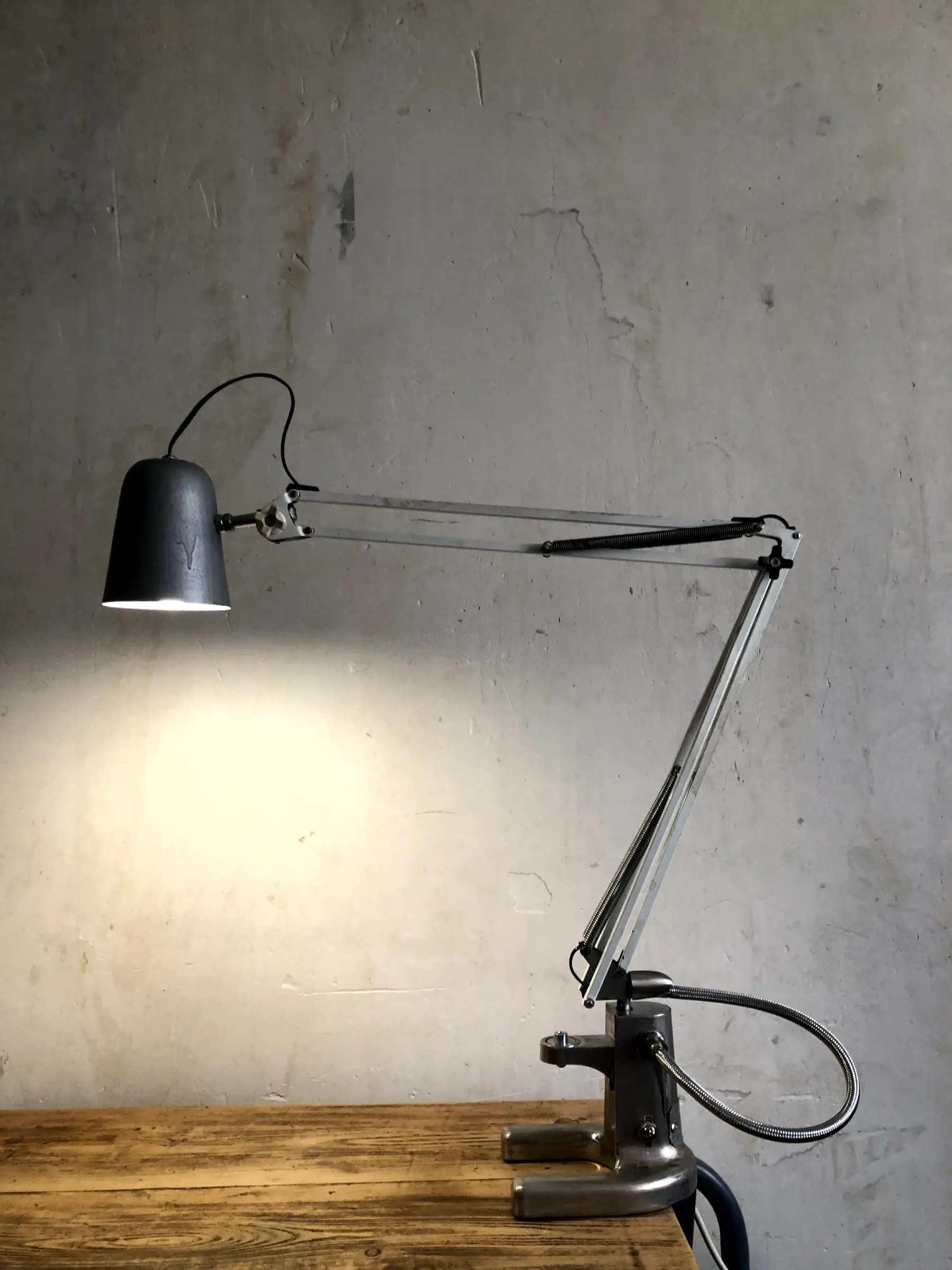 La lampe Luxo allumée et fixée sur un bureau