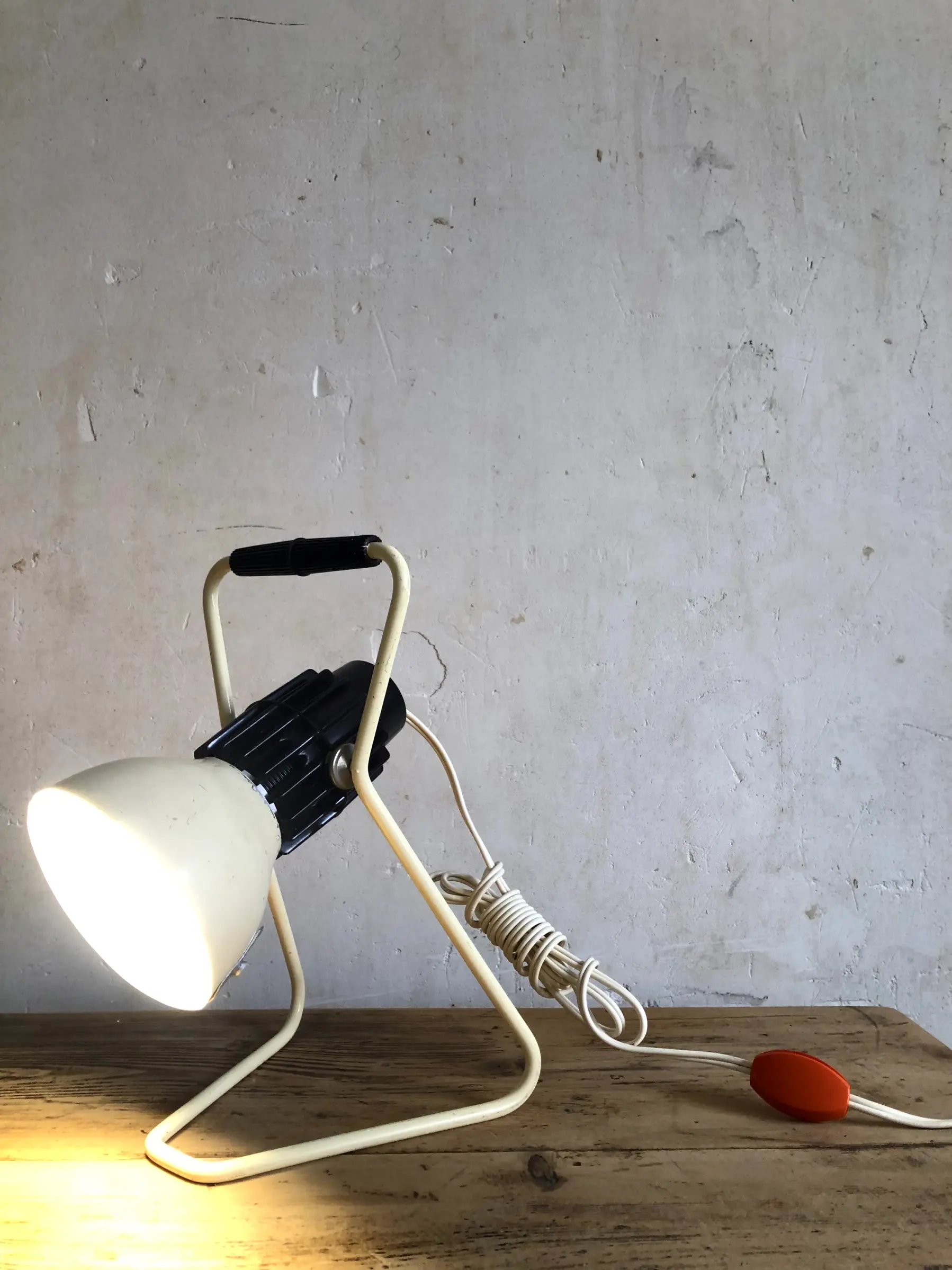 La lampe Omni allumée et posée sur un bureau, en position basse