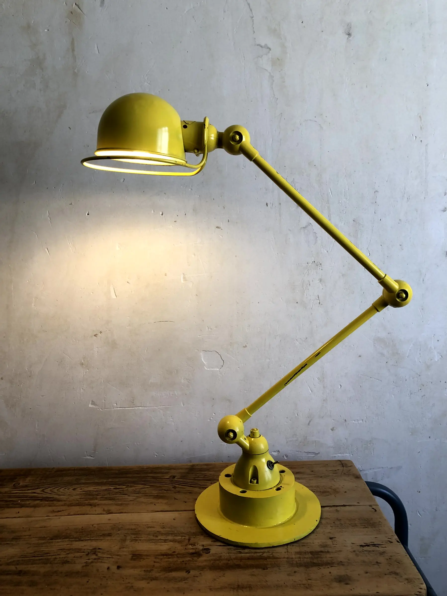 La lampe Yeld allumée et posée sur un bureau